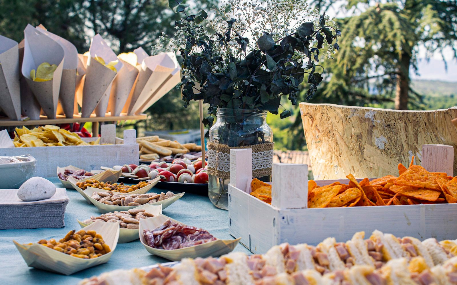 An abundant catered spread on a warmly lit table as guests gather to serve themselves